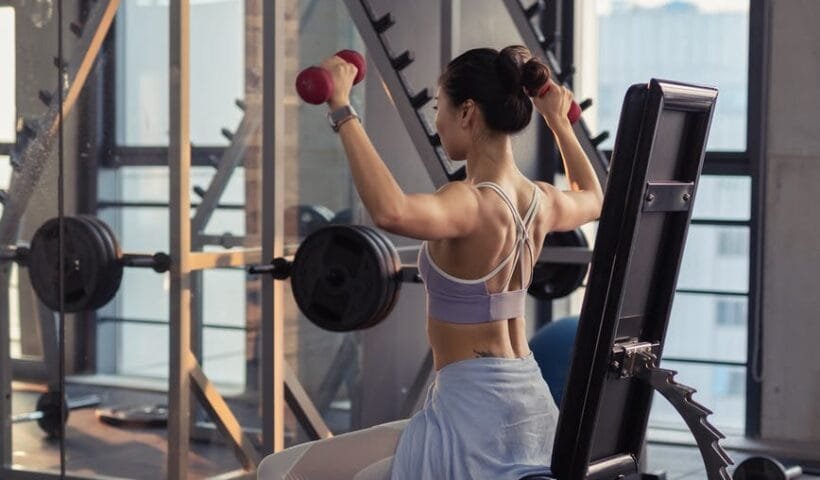 photo of woman raising dumbbells