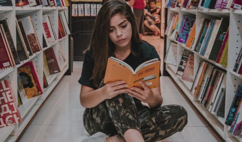 woman sitting on floor while reading