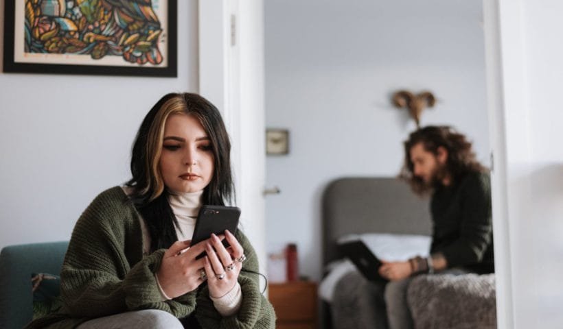 calm young couple using gadgets during weekend at home