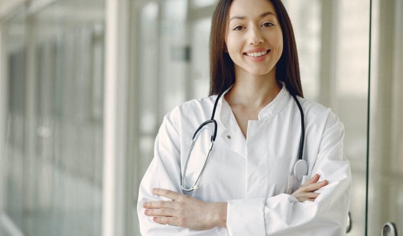 crop doctor in medical uniform with stethoscope standing in clinic corridor