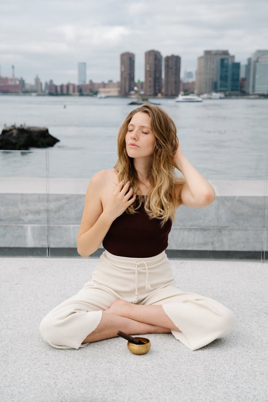 a woman sitting on the floor with a tibetan singing bowl