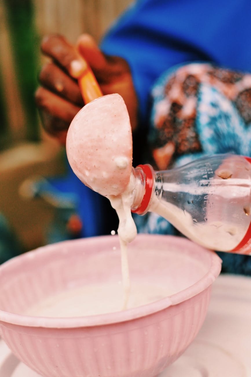 a person is pouring milk into a bowl