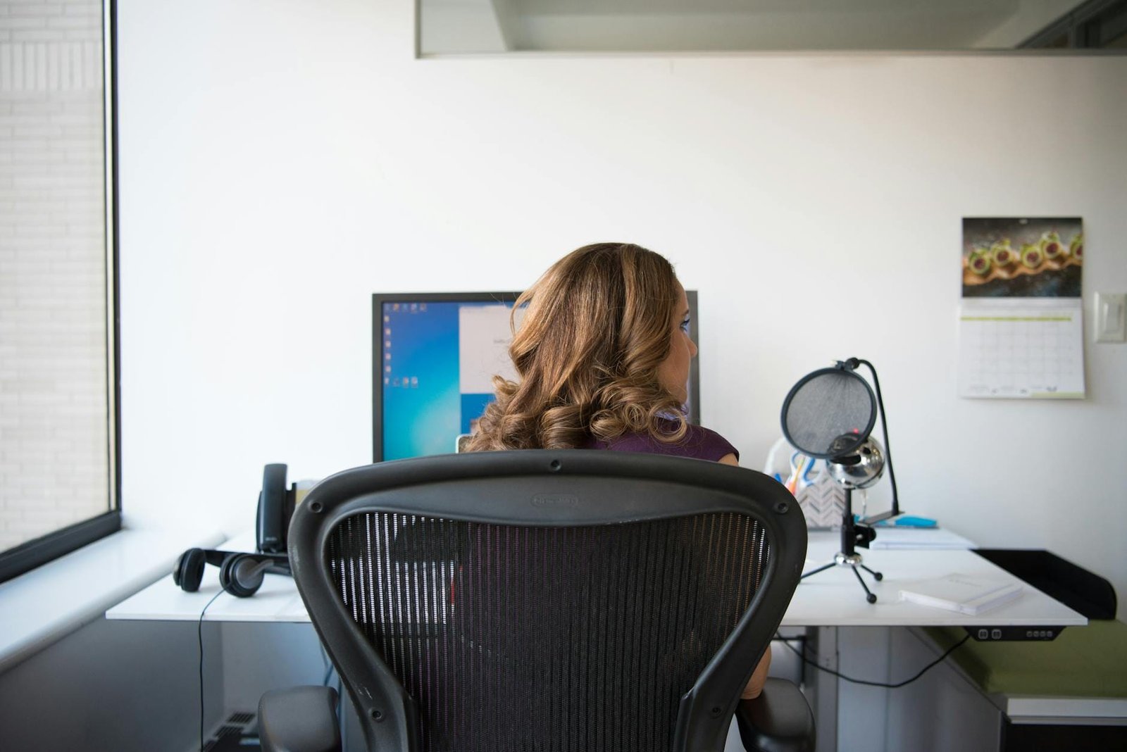 woman siting on chair in front of turn on computer monitor
