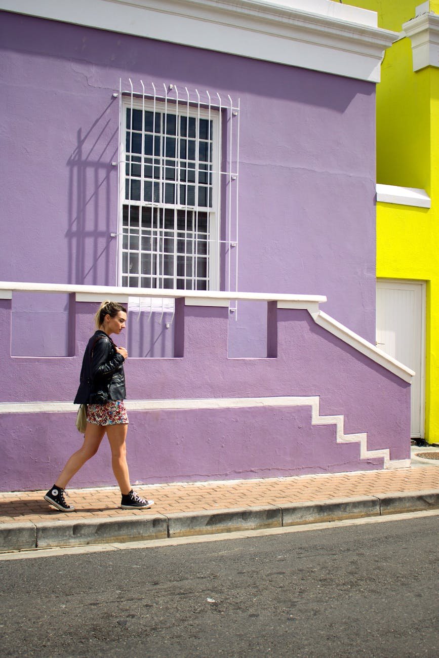 woman walking near purple painted building